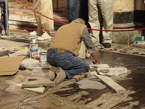 An artisan repairing the floor of the Duomo, from the rear