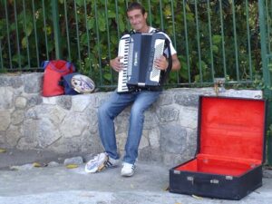 A street musician performing at a rest point (in the shade) 