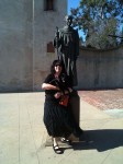 Aviva holding Iggy in front of a statue of the founder of the Mission
