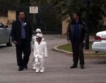 Two young boys, in white suits, coming from a sweet 16 celebration at the Mission Two young boys, in white suits, coming from a sweet 16 celebration at the Mission