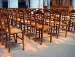 Chairs in the light of the stained glass windows