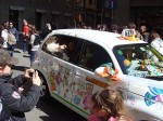 A decorated taxi with a pretty girl giving out candy!