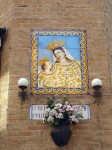 A votive on the wall at a street corner